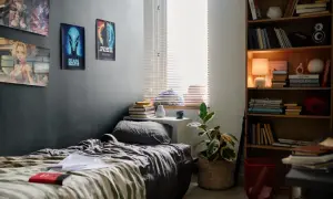 Mały wąski pokój młodzieżowy z plakatem kosmity, anime i książkami.