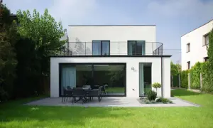 Nowoczesna przebudowa domu z lat 70. Biała bryła z dużymi przeszkleniami i tarasem. Projekty architektoniczne.