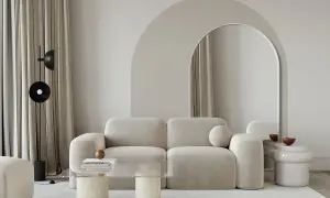 Nowoczesny salon z beżową kanapą i łukiem nad lustrem. Świetny pomysł na łuk w domu, który optycznie powiększa przestrzeń.