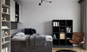 Nowoczesne pokój 7m2 aranżacje: szare łóżko, regały z książkami, czarne meble, brązowy fotel i geometryczna tapeta.
