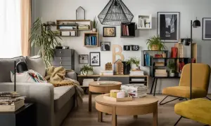 Nowoczesne półki na ścianę inspiracje: salon z szarą kanapą, drewnianymi stolikami i żółtym fotelem.
