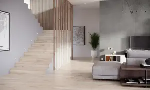 Nowoczesna klatka schodowa projekt z drewnianymi balustradami i subtelnym oświetleniem. Obok salon z szarą ścianą i wygodną sofą.