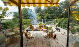 Przytulny projekt domu z tarasem, gdzie grill i kwiaty tworzą atmosferę letniego wieczoru.