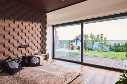 Sypialnia z widokiem na plac zabaw i ogród. Wnętrze w stylu feng shui dom, z dużą ilością naturalnego światła i harmonijnymi kolorami.