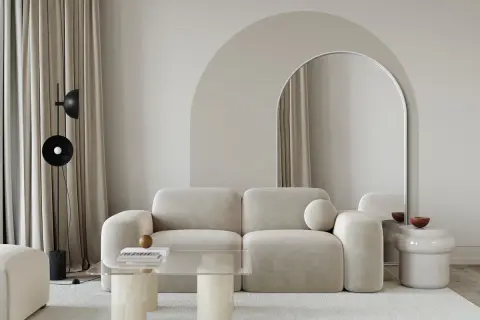 Nowoczesny salon z beżową kanapą i łukiem nad lustrem. Świetny pomysł na łuk w domu, który optycznie powiększa przestrzeń.