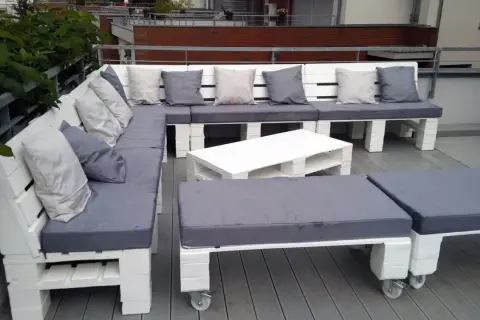Narożna sofa i stolik kawowy z palet, pomysły na meble z palet. Szare poduszki dodają przytulności.