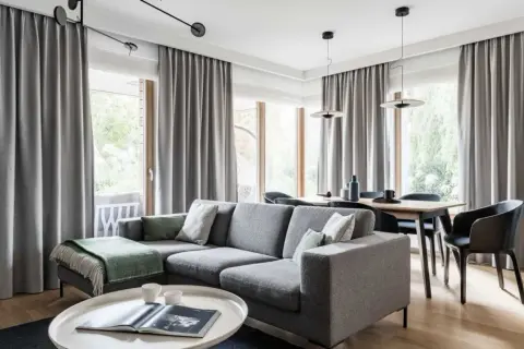 Szare zasłony tworzą przytulną atmosferę w salonie z jadalnią. To świetne rozwiązanie, co zamiast zasłon, dodające elegancji i prywatności.