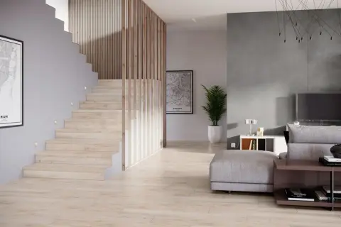 Nowoczesna klatka schodowa projekt z drewnianymi balustradami i subtelnym oświetleniem. Obok salon z szarą ścianą i wygodną sofą.