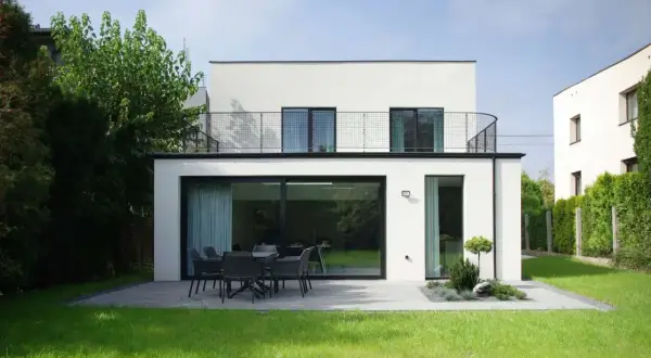 Nowoczesna przebudowa domu z lat 70. Biała bryła z dużymi przeszkleniami i tarasem. Projekty architektoniczne.