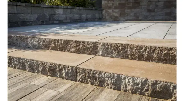 Solidne schody z bloczków betonowych prowadzą na taras. Kamienne stopnie z chropowatą fakturą.