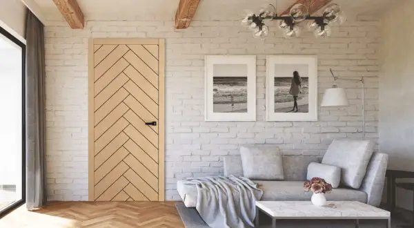 Przytulny salon w stylu modern farmhouse z drewnianą podłogą, ceglaną ścianą i dwoma obrazami z motywem morza.