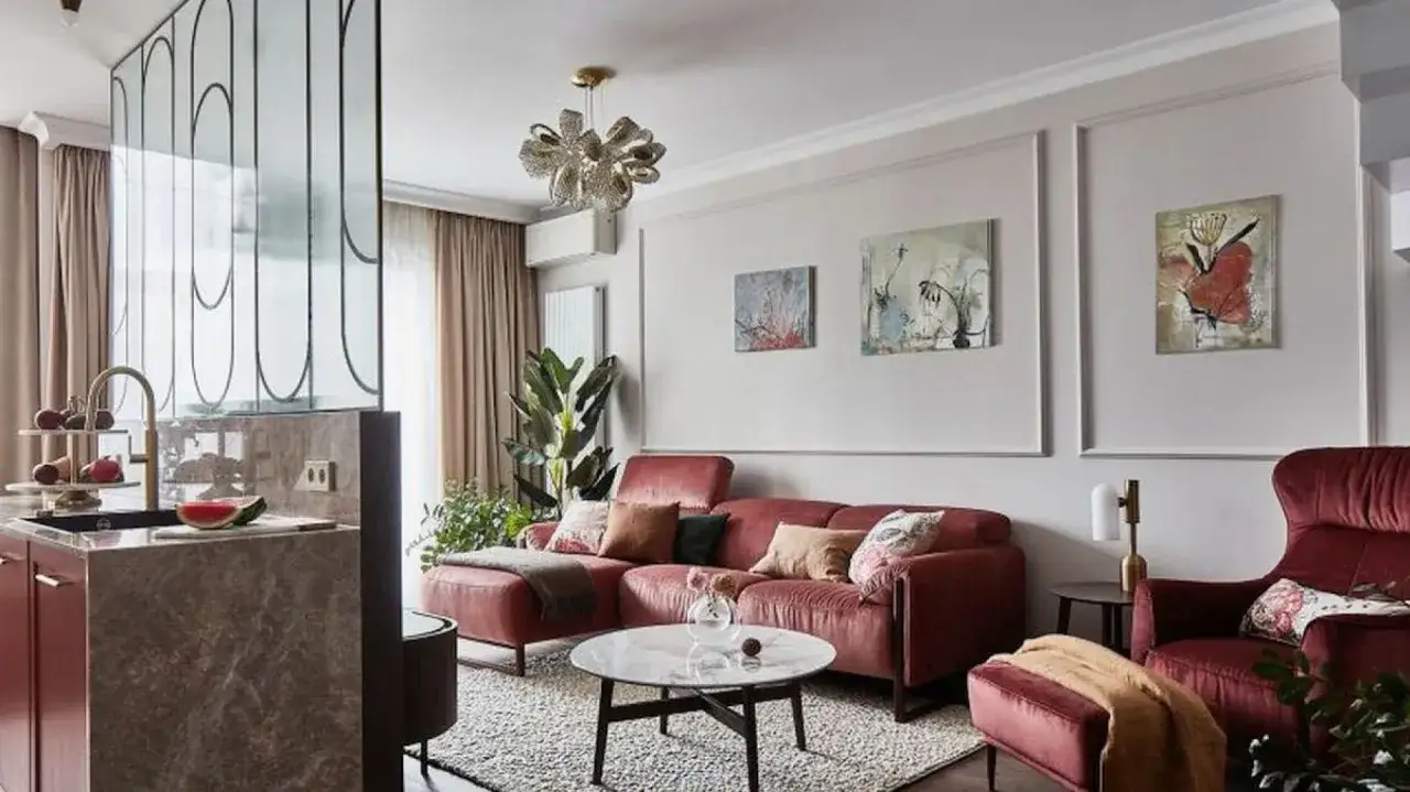 Eleganckie obrazy nad kanapą to świetny sposób, jak ozdobić ścianę w pokoju. Wnętrze w odcieniach różu i beżu.