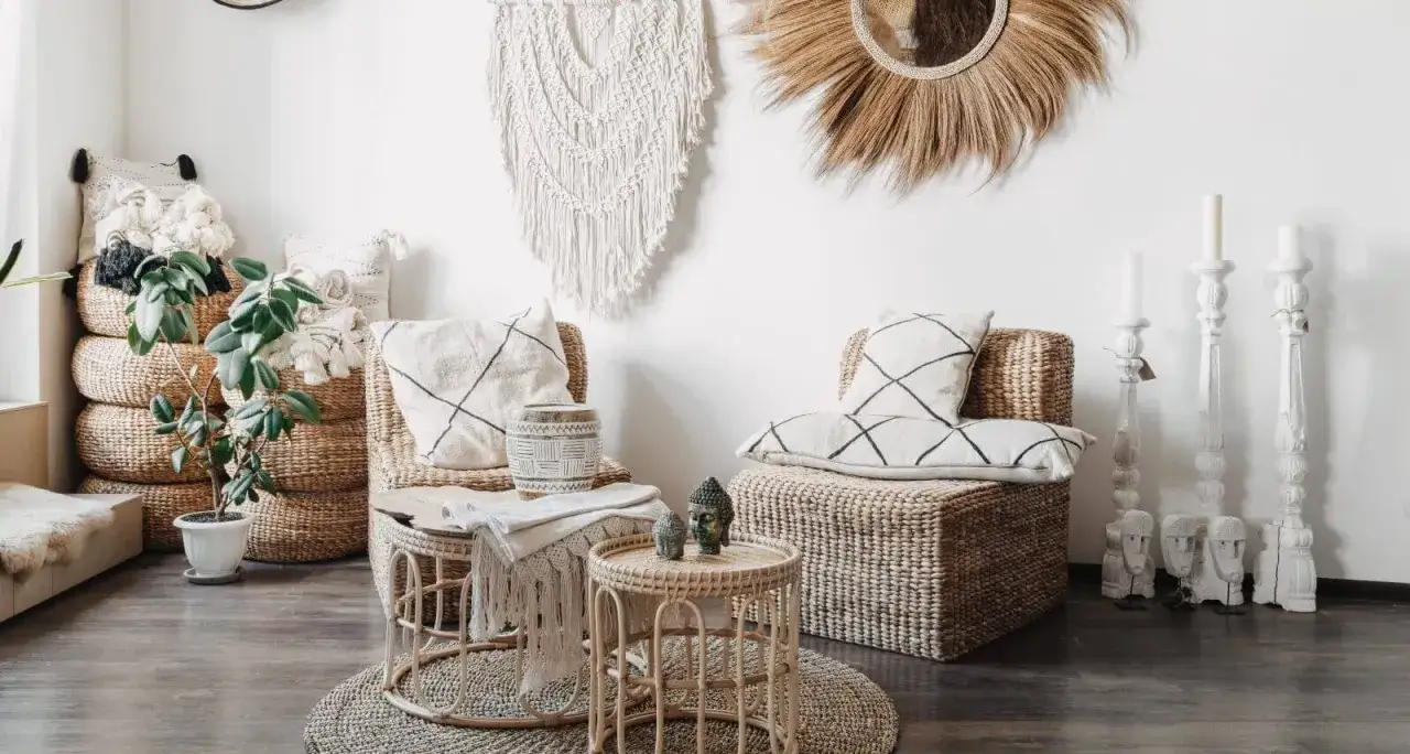Przytulny pokój w stylu boho z wiklinowymi meblami, makramą na ścianie i roślinami.