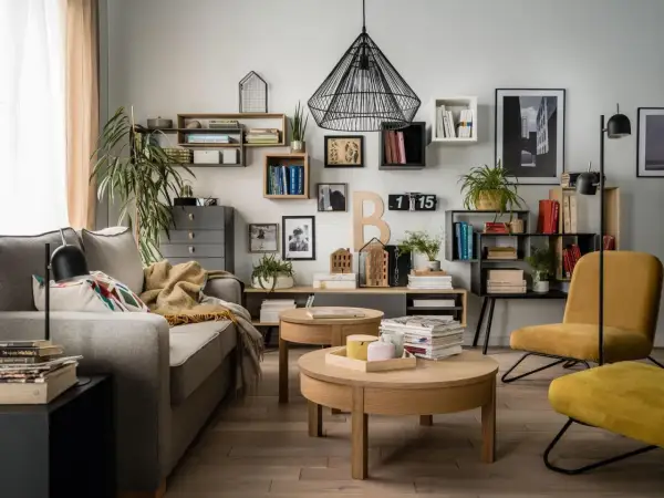 Nowoczesne półki na ścianę inspiracje: salon z szarą kanapą, drewnianymi stolikami i żółtym fotelem.